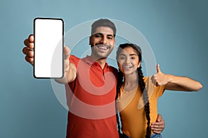 Cool App. Happy Arab Couple Demonstrating Blank Smartphone And Showing Thumb Up