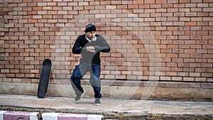 A cool Asian male b-boy breakdancer is dancing on the footpath, performing his breakdance outdoors