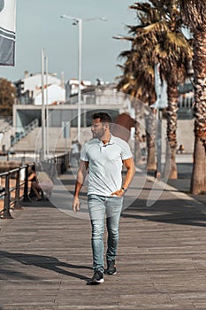 Cool and attractive Slovenian male walking on a portside