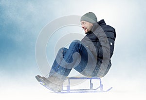 Cool bearded man on a sled in the snow