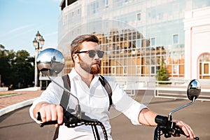 Cool bearded man in sunglasses with backpack rides