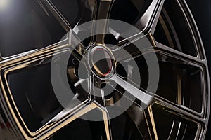 Cool black aluminum die-cast car wheel on dark background, lightweight forged alloy wheels. fashionable, lightweight, durable and