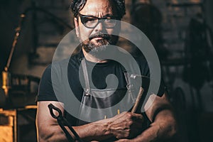 Blacksmith portrait with beard in workshop