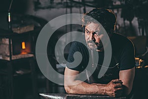 Cool blacksmith portrait in workshop