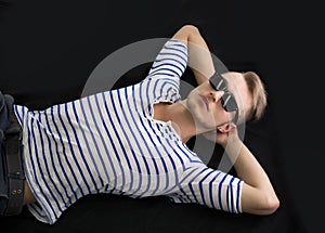 Cool blond young man laying on the floor with sunglasses on