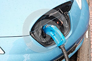 Cool blue car getting charged to be ready to take off