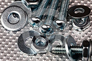 cool blue toned macro of small bolts with nuts and washers on an industrial steel surface. Strong Contrast