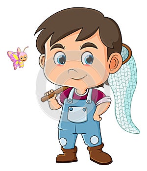 The cool boy is ready to catch a cute small butterfly while holding net