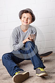 Cool Boy sitting on his skateboard, Laughing.