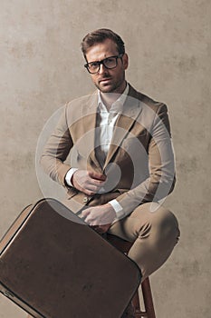 Cool businessman posing with class on a chair