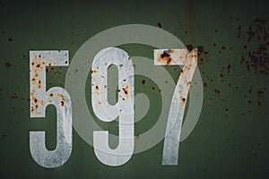 Cool closeup look of white numbers on a rusty old green metal - a good background and wallpaper