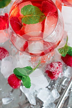 Cool cocktail with ice and mint and raspberry. Summer.