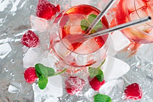 Cool cocktail with ice and mint and raspberry. Summer.