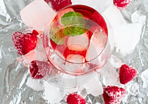 Cool cocktail with ice and mint and raspberry. Summer.