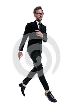 Cool elegant man in black suit holding hand in a fashion pose