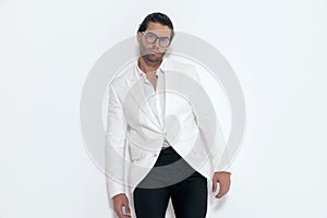 cool fashion man wearing white jacket suit and glasses and posing