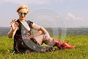 Cool fashionable woman posing wearing dress and shades showing o