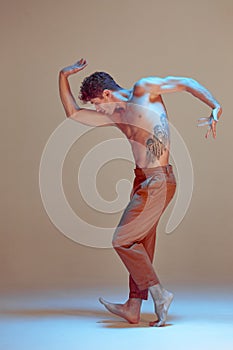 Cool flexible young man dancer dancing in neon light. Dance school poster. Dance lessons. Body with tattoos.