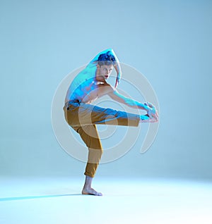 Cool flexible young man dancer dancing without shirt in neon blue light. Dance school poster. Dance lessons