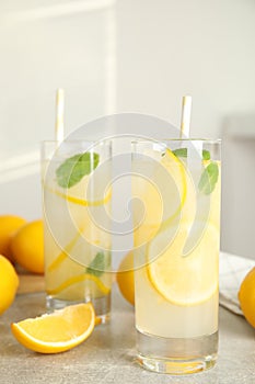 Cool freshly made lemonade and fruits on grey table