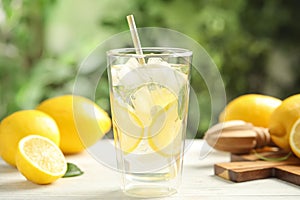 Cool freshly made lemonade and fruits on white wooden table, closeup