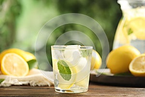 Cool freshly made lemonade and fruits on wooden table