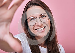 Cool girl in glasses in T-shirt and glasses takes a selfie