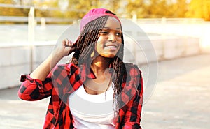 Cool girl having fun in the city park, wearing a red checkered shirt