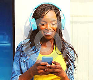 Cool girl in a headphones listens to music using smartphone