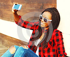 Cool girl is taking picture self portrait on smartphone having fun