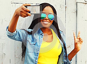 Cool girl taking self-portrait photo on a smartphone