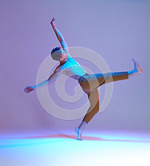 Cool guy breakdancer dancing hip-hop in lilac neon light in studio. Colorful dance school poster. Break dance lessons