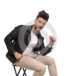 Cool guy with nice hair style is sitting on a chair