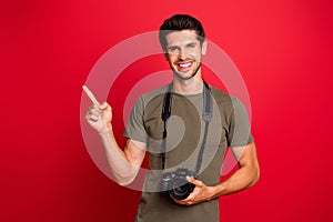 Cool guy with photo digicam indicate finger empty space on low prices banner wear t-shirt isolated on red background