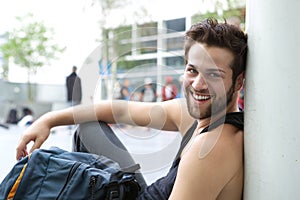 Cool guy sitting outdoors with bag