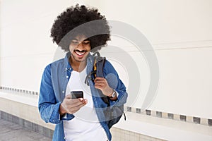 Cool guy walking with mobile phone and bag