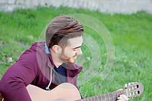 Cool handsome guy with beard playing guitar