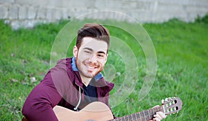 Cool handsome guy playing guitar at outside