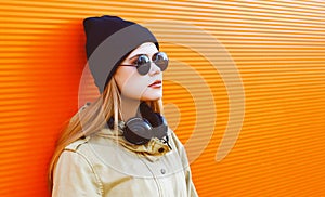 Cool hipster girl wearing a black hat and headphones