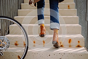 Cool hipster man walking up the stairs in modern city. Lowsection close-up. Steps forward into a success photo