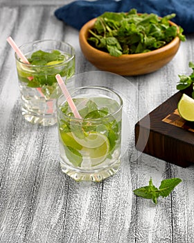 Cool lemonade with mint and lime and ice in glass cups