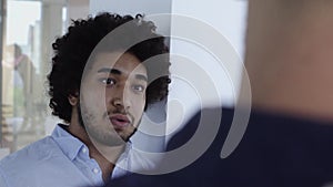 Cool looking middle eastern man with afro chatting in office