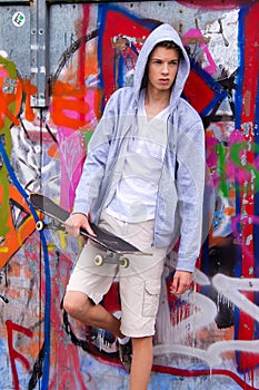Cool-looking young man in front of graffiti