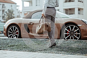 Cool man beautiful model outdoors, city style fashion. A handsome man model walking in the city center next to some cars