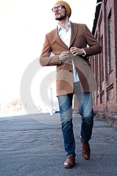 Cool man beautiful model outdoors, city style fashion. A handsome man model walking in the city center. Urban setting