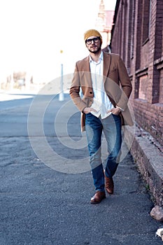 Cool man beautiful model outdoors, city style fashion. A handsome man model walking in the city center. Urban setting