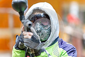 Cool paintball player aiming in camera. Closeup.