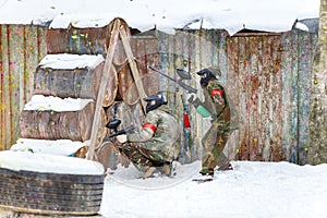 Cool paintball in winter. Two shooters behind fortifications.