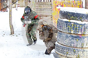 Cool paintball in winter. Two shooters behind fortifications.