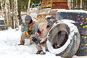 Cool paintball in winter. Two shooters behind fortifications.